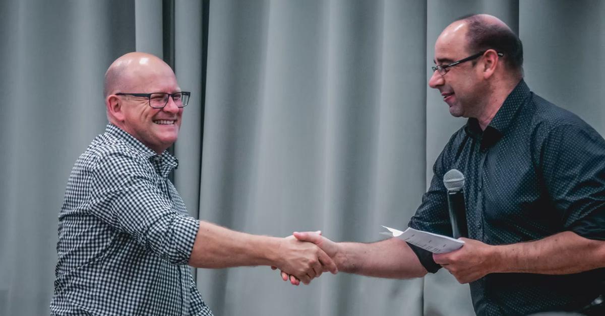 Men shaking hands after winning an award